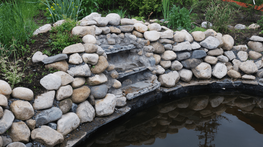 Arrange rocks and stones along the edge to create a natural transition between the water and the surrounding landscape.